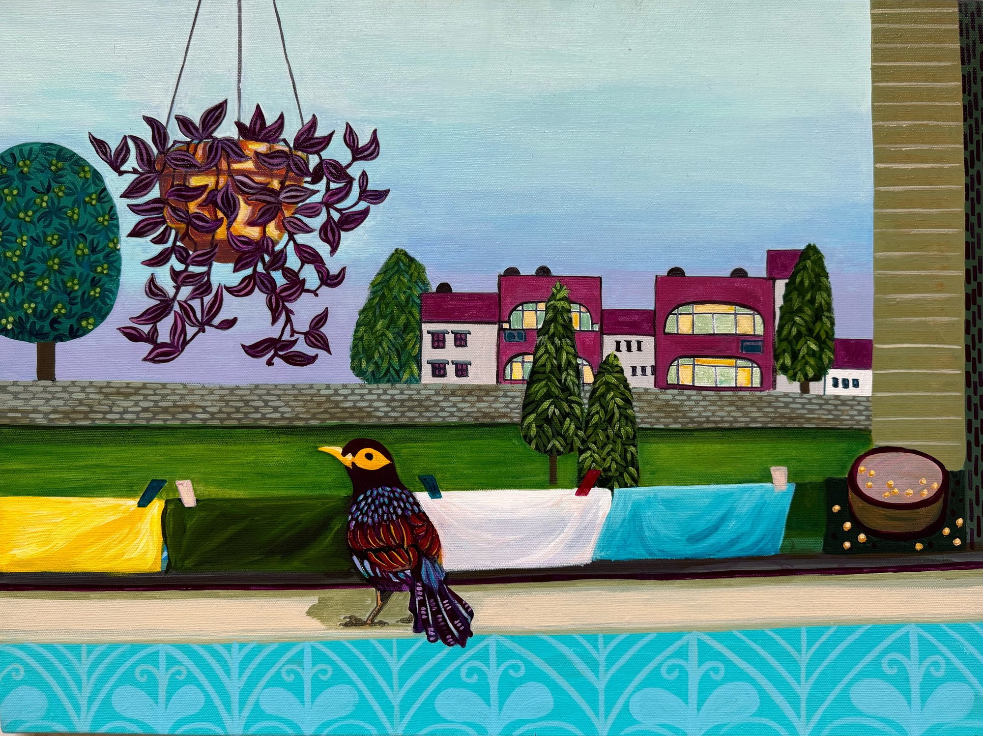 A solitary bird on a balcony overlooking washing, trees and distant houses.
