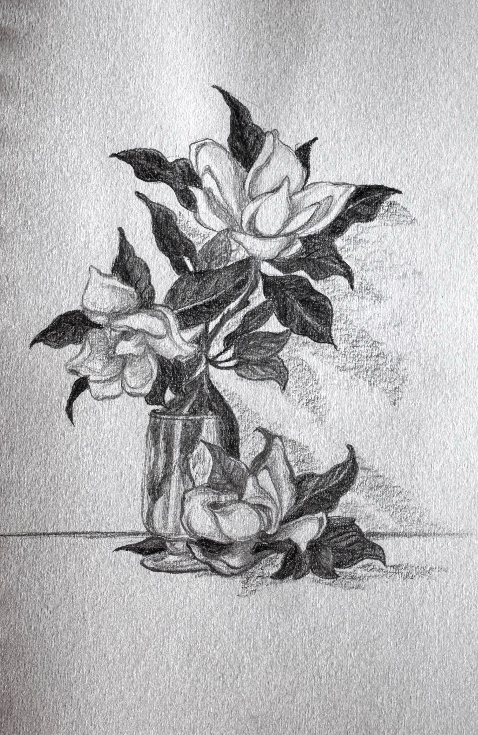 Softly shaded flowers and leaves arranged in a glass.